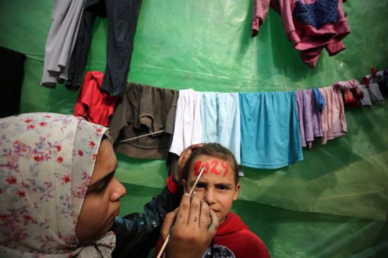<em>战火</em>中成长的童年：加沙孩童面部绘制2024字样迎新年