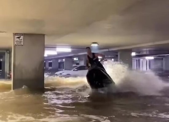 澳大利亚男子在被洪水淹没的停车场内骑摩托艇<em>追求</em>刺激<em>被</em>批
