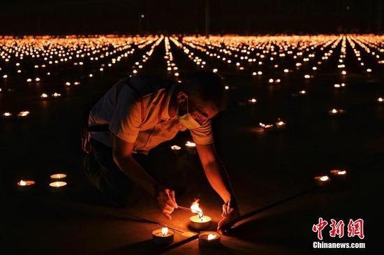 泰国点燃33万根蜡烛拼成世界最大火焰图像 创吉尼斯世界纪录